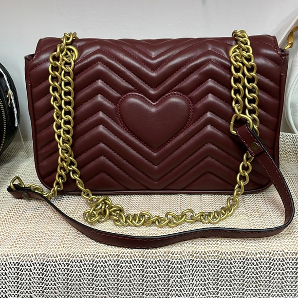 It is a dark, red woman handbag, long strap